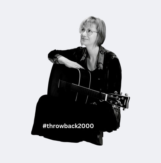 A photo of Ruth Nina Welsh sitting with her guitar.